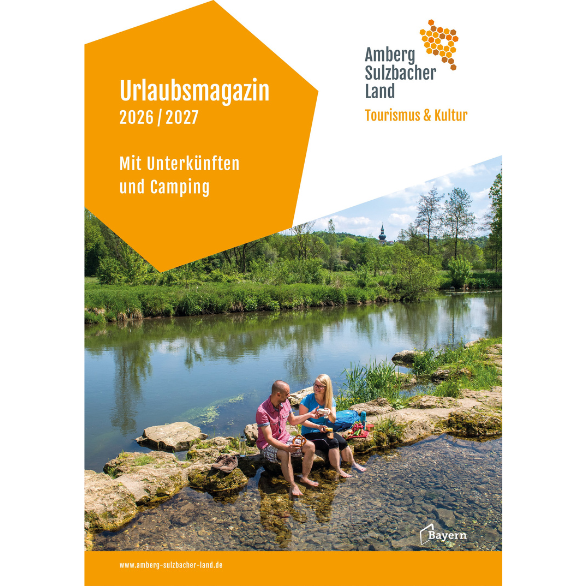 Das Titelbild zeigt zwei Urlauber am Fluss, die Picknick machen. Das Prospekt trägt den Titel "Urlaubsmagazin 2026/2027, mit Unterkünften und Camping"