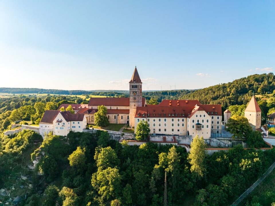 In der Abendsonne thront die Klosterburg-Anlage mit Kirchturm über dem Ort